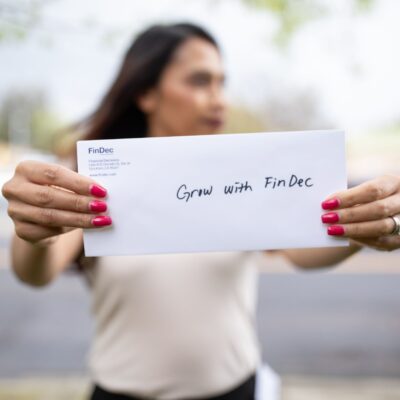 Woman holding an envelop that says, "Grow with FinDec."