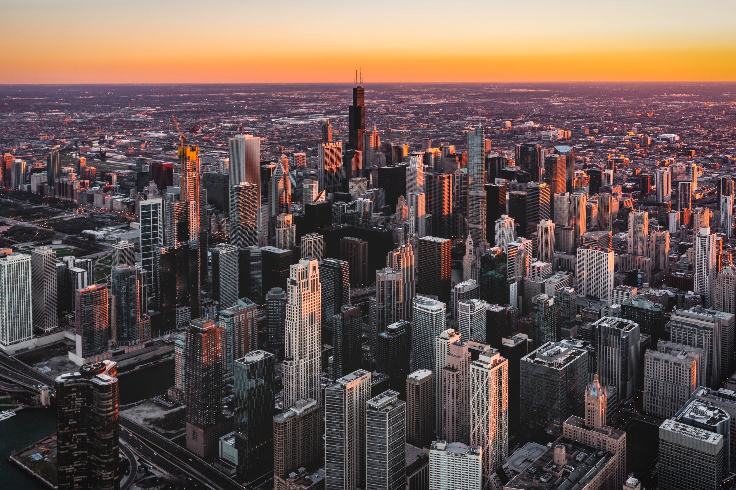 City scape of Chicago with the sun setting in the background.