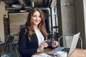 Portrait of a business working working at her desk as she smiles at the camera.