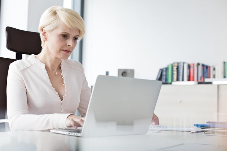 A business woman working on her computer at her desk.