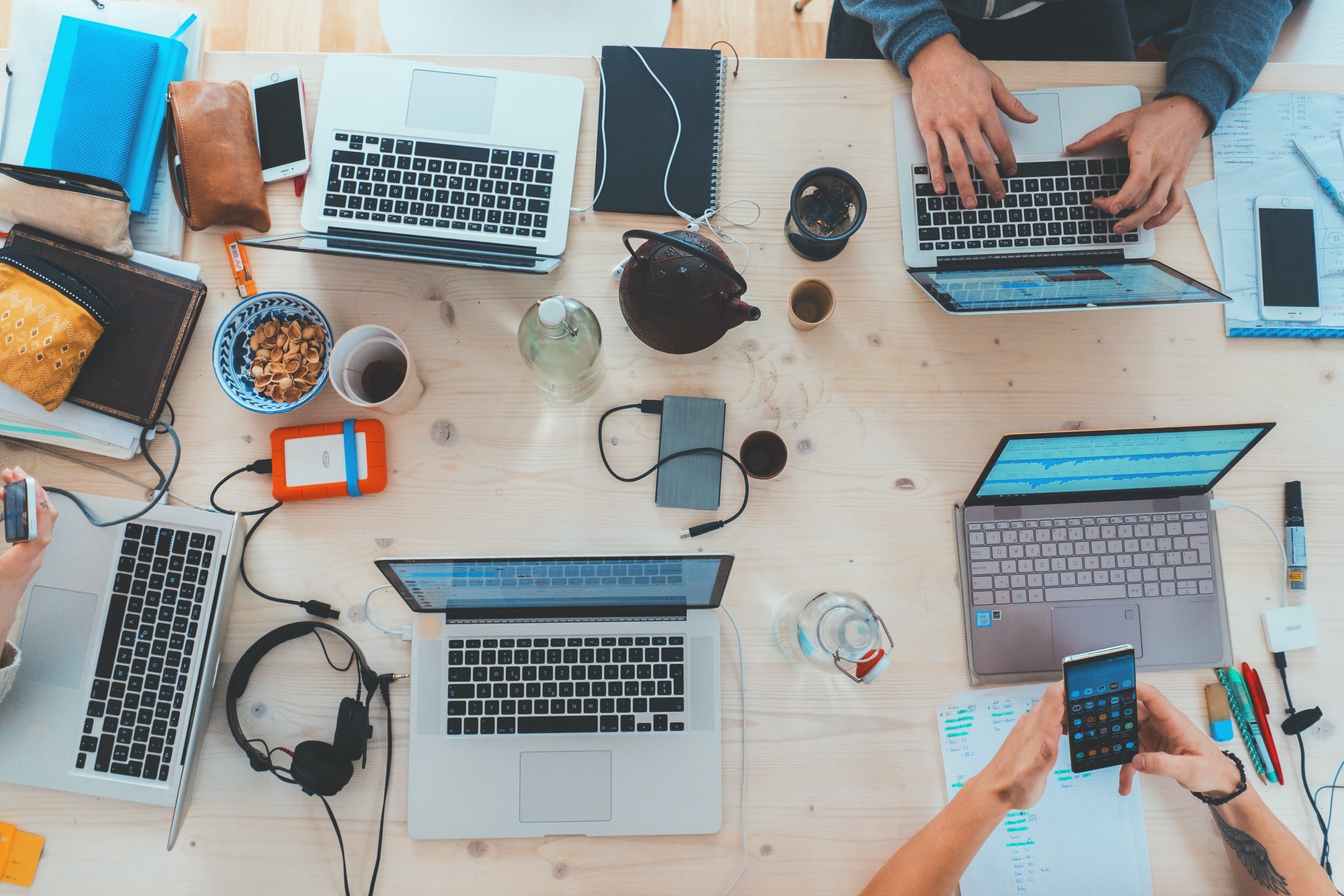 People working together on their devices at a conference table.