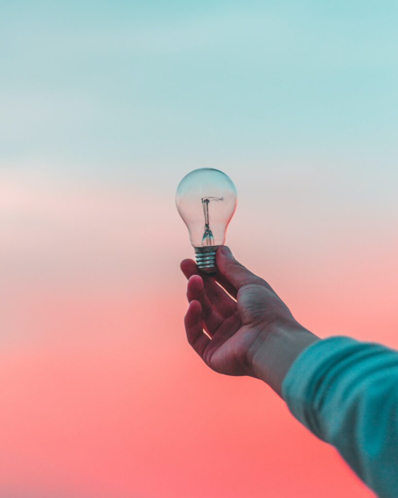 A person holding an unlit lightbulb.