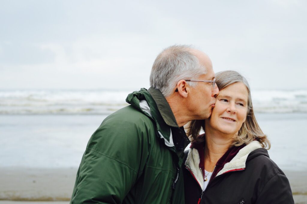 A senior couple kissing at the beach.
