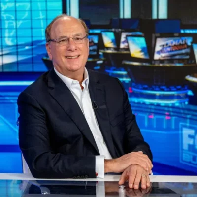 Person sitting behind desk in television studio.