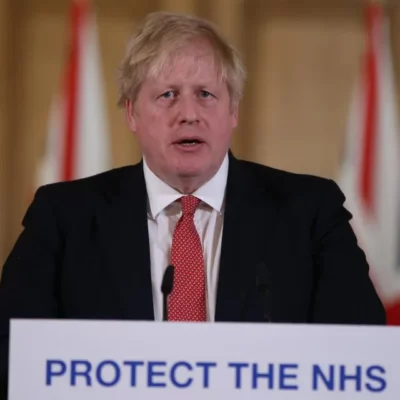 Boris Johnson speaking at a podium.