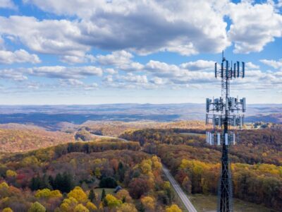 Cell tower above a field of trees in autumn.