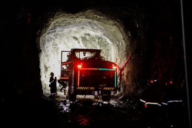 Truck and worker in a dark tunnel.