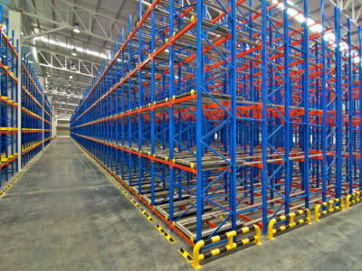 Empty warehouse with blue and red storage racks.