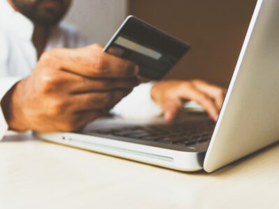 Person holding credit card while shopping online.